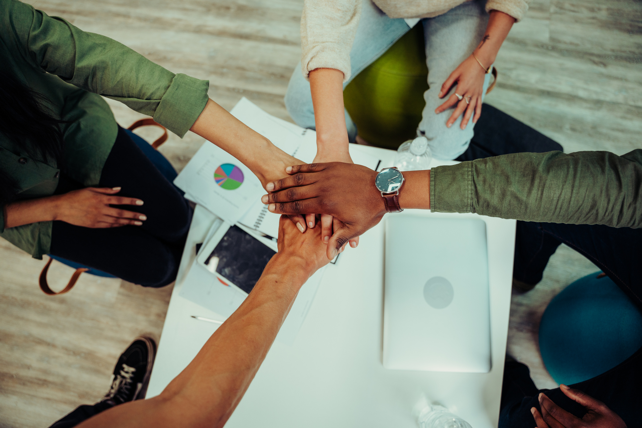 People putting their hands together in celebration of teamwork and helping eachother